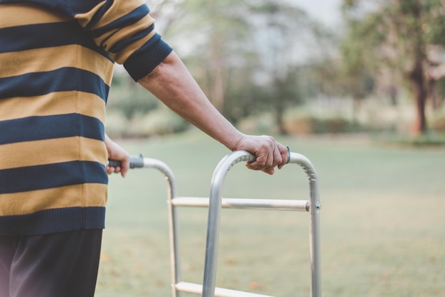 Senior vrouw handen met rollator proberen te lopen bij de natuur fysiotherapie concept