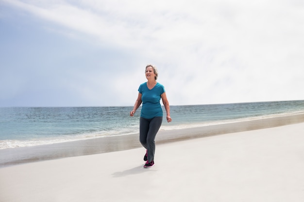 Senior vrouw joggen op het strand