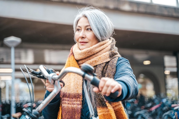 Senior vrouw krijgt de fiets op een parkeerplaats