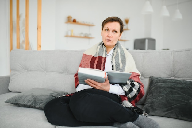 Senior vrouw leesboek thuis