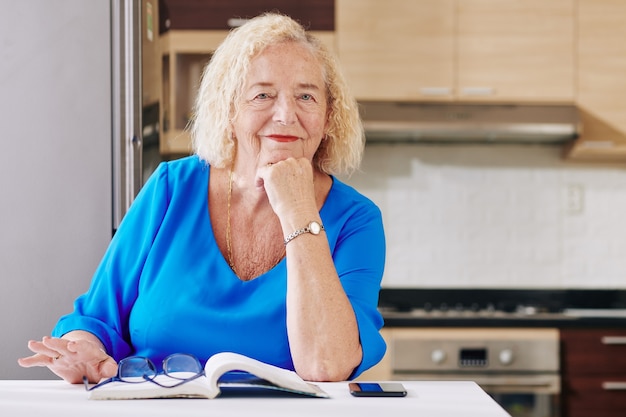 Senior vrouw lezen in de keuken