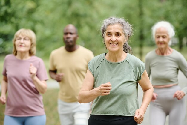 Senior vrouw loopt met haar vrienden buiten in het park