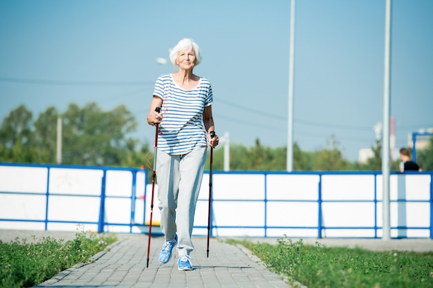 Senior vrouw lopen met palen