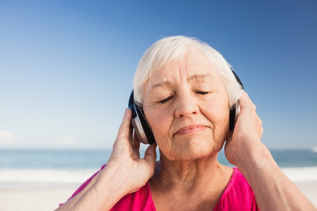 Senior vrouw luisteren muziek met koptelefoon