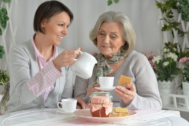 Senior vrouw met dochter met thee en eten