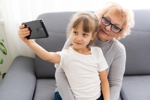 Senior vrouw met kleinkind speelspel op smartphone.