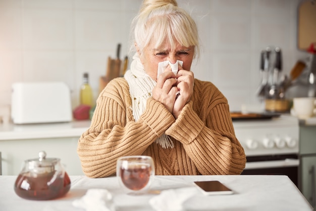 Senior vrouw met loopneus en zich niet lekker voelen