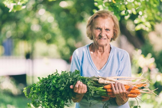 Foto senior vrouw met vers gewas uit haar tuin