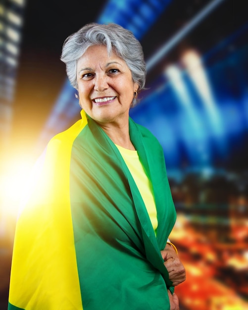 Senior vrouw met vlag van Brazilië op bokeh-achtergrond juichen voor Brazilië om de kampioen te worden