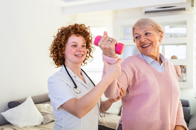 Senior vrouw na een beroerte in verpleeghuis oefenen met professionele fysiotherapeut.