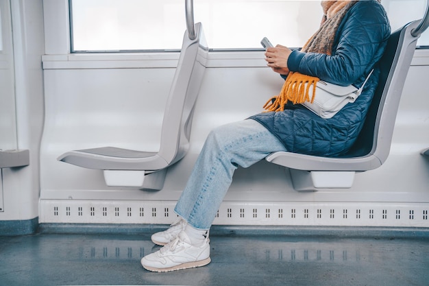 Senior vrouw stuurt bericht met een mobiele telefoon in een trein