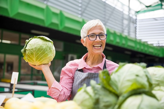 Senior vrouw verkoopt fruit op de markt