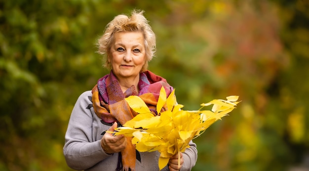 Senior vrouw wandelen in het park in de herfst