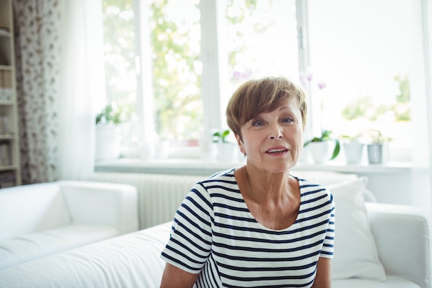 Senior vrouw zittend op de bank in de woonkamer