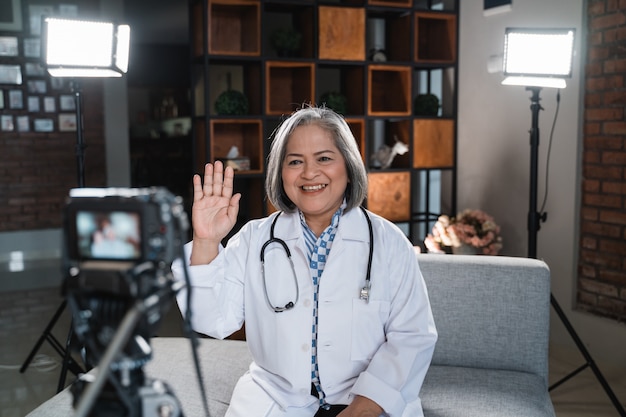 Senior vrouwelijke arts neemt een video op van haar blog