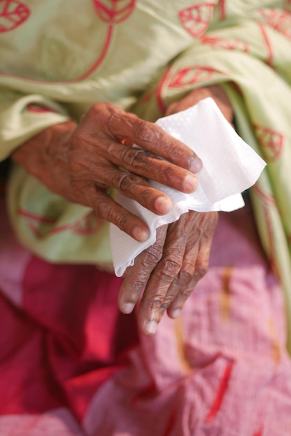 Senior vrouwen desinfecteren zijn handen met een nat doekje