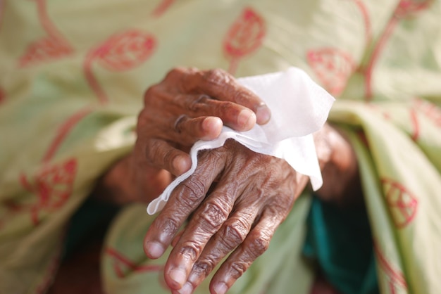 Senior vrouwen desinfecteren zijn handen met een nat doekje