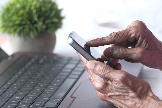 Senior vrouwen hand met behulp van slimme telefoon close-up.