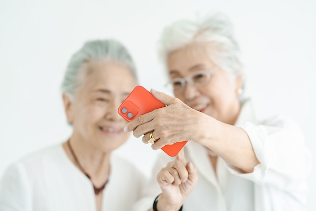 Senior vrouwen kijken met een glimlach naar smartphoneschermen