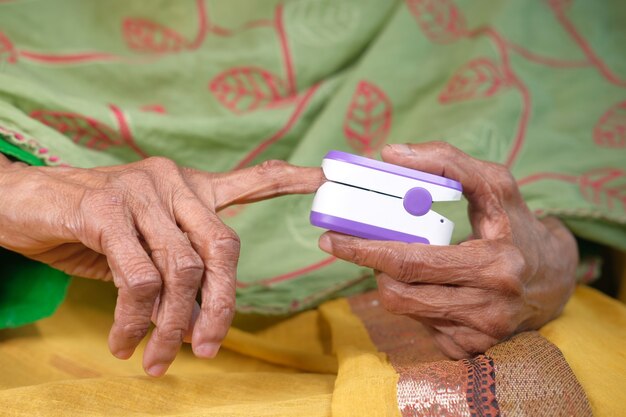 Senior vrouwen overhandigen pulsoximeter.