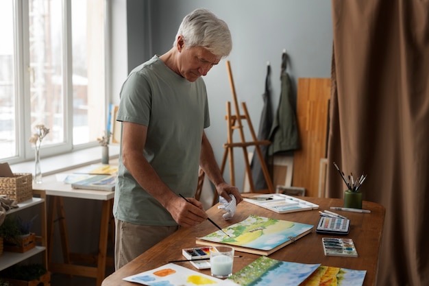 Photo senior watercolorist in the studio working on his art