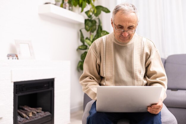 Senior werkt op een laptop, oudere man.