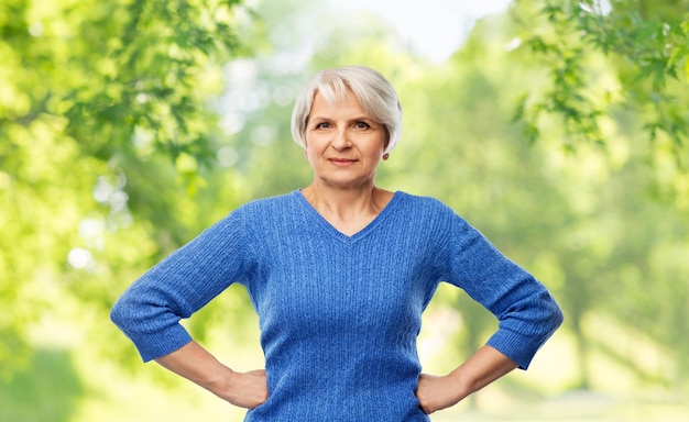 Photo senior woman in blue sweater hands on hips