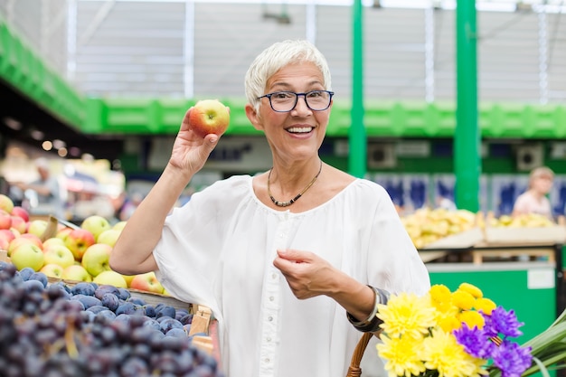 Senior woman buying fruit on market