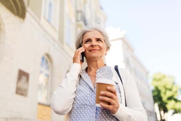 Foto donna anziana che chiama su uno smartphone in città