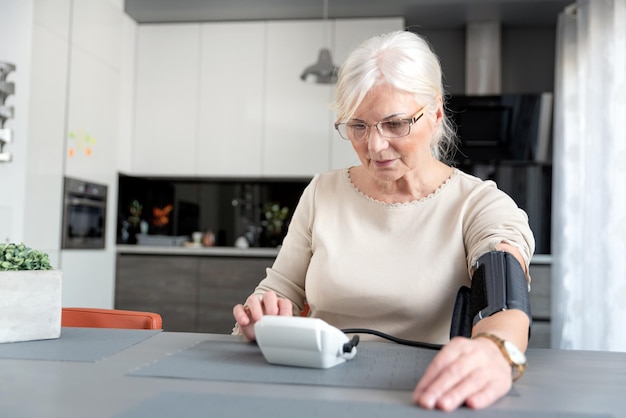 senior woman checking blood pressure at home