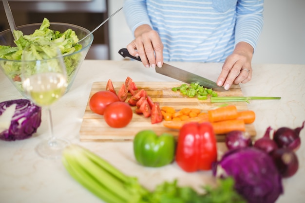 写真 年配の女性が野菜を切る