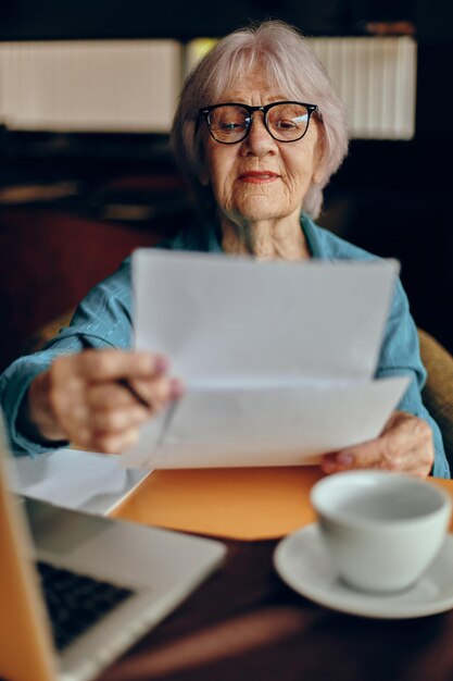 Senior woman documents work sheet of paper and pen Social networks unaltered