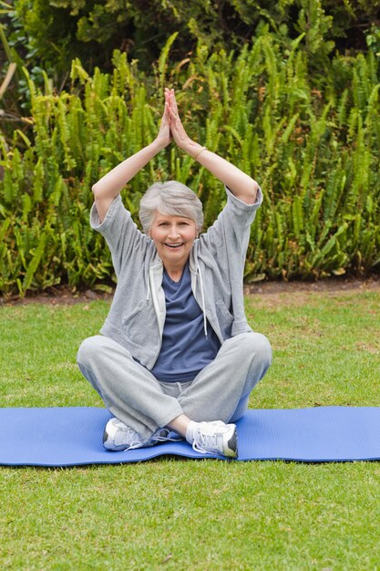 Senior woman doing her streches in the garden