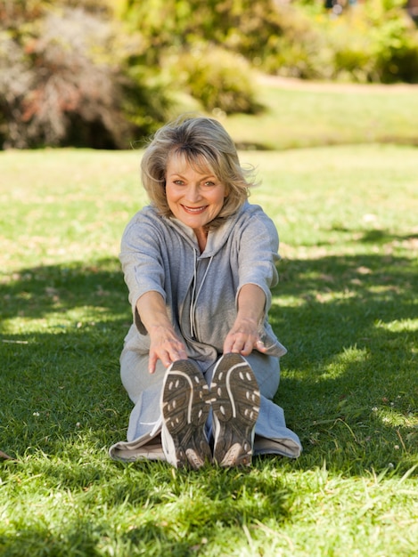 Senior woman doing her streches in the park