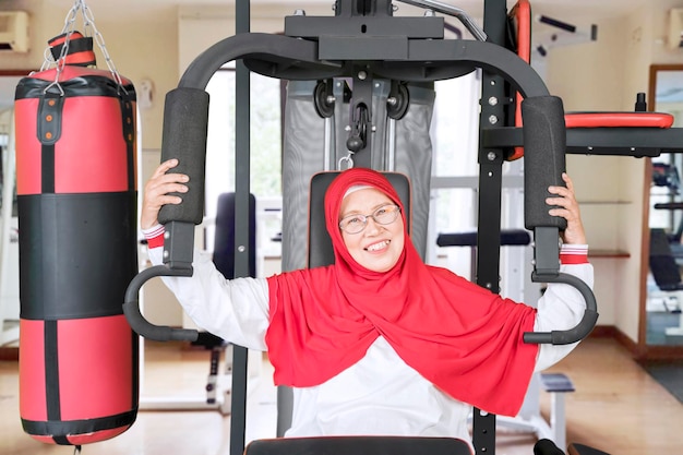 Senior woman doing workout on gym machine