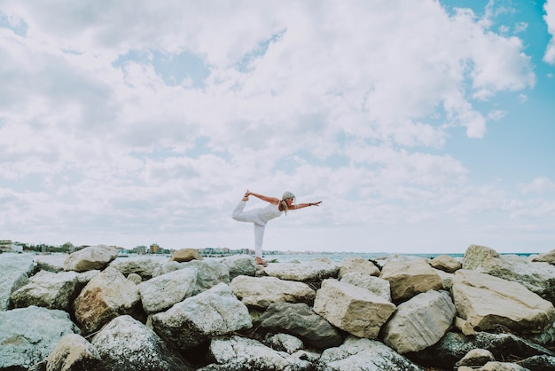 Senior woman doing yoga exercise at beach