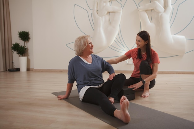 Senior woman doing yoga with professional instructor