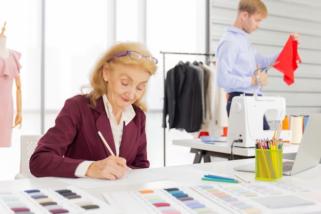 Photo senior woman drawing sketch in office