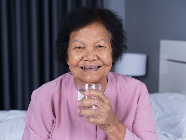 寝室でシニアの女性の飲料水