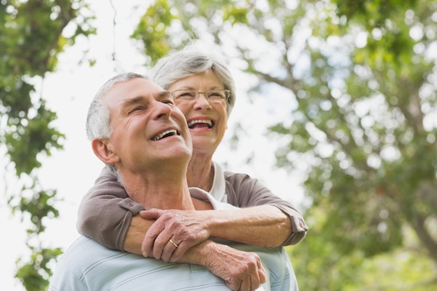 Senior woman embracing man from behind