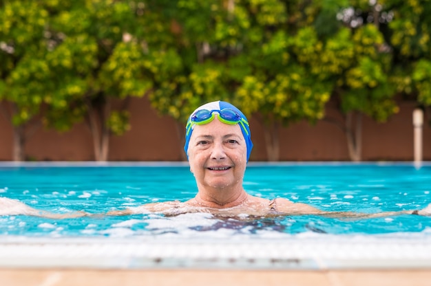 Senior woman enjoying practices activity outdoor in the swimming pool