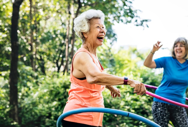 Photo senior woman exercising with a hula hoop