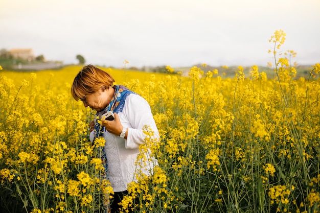 Senior woman in a field of yellow flowers