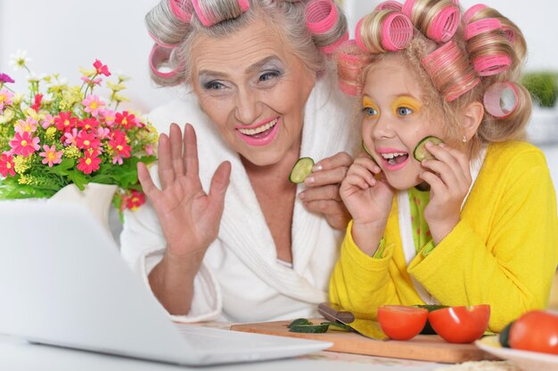 Senior woman and girl using laptop