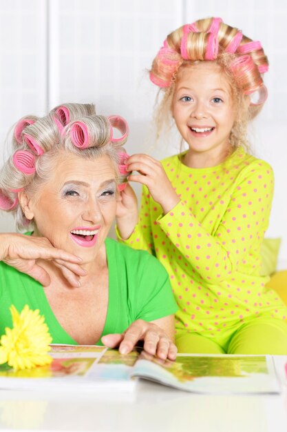 Senior woman and granddaughter doing hairstyle at home