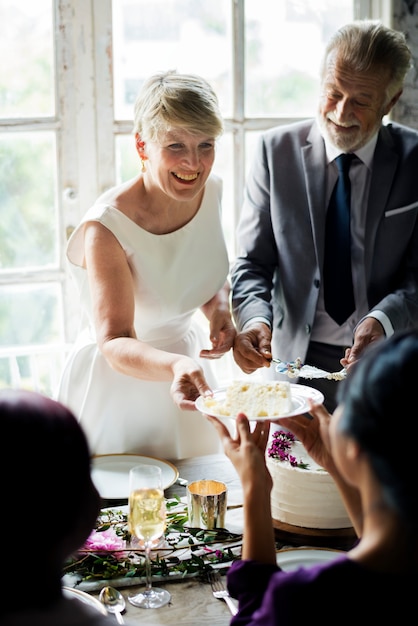 Senior Woman Handing Cake to Friend