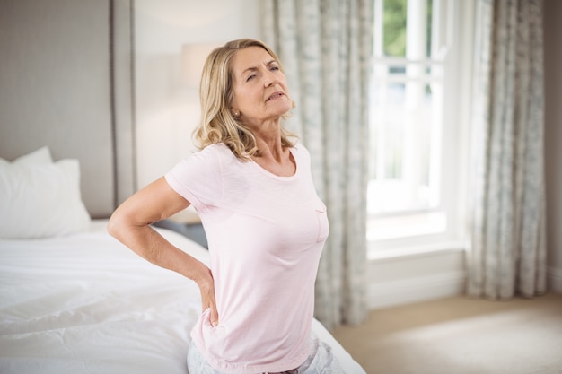 Donna senior che ha dolore alla schiena in camera da letto