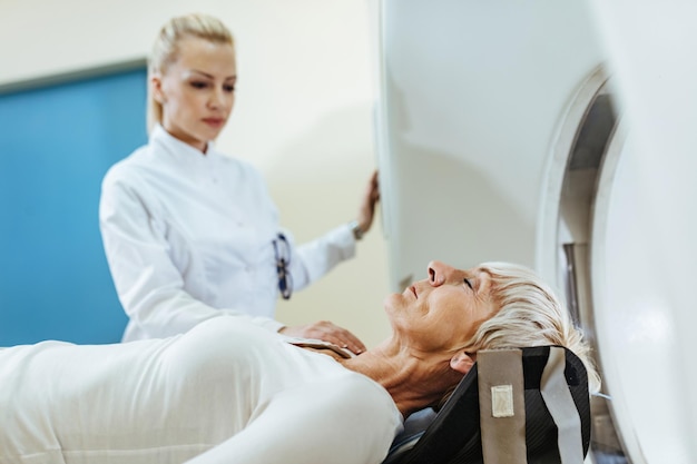 Senior woman having medical examination with mri scanner at clinic