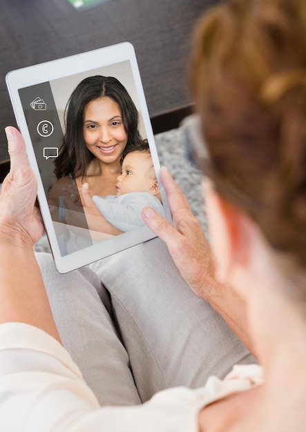 Photo senior woman having a video call with her daughter in digital tablet