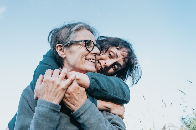 Senior woman and her daughter smiling and having fun on the nature during a sunny day. Happy mother's day